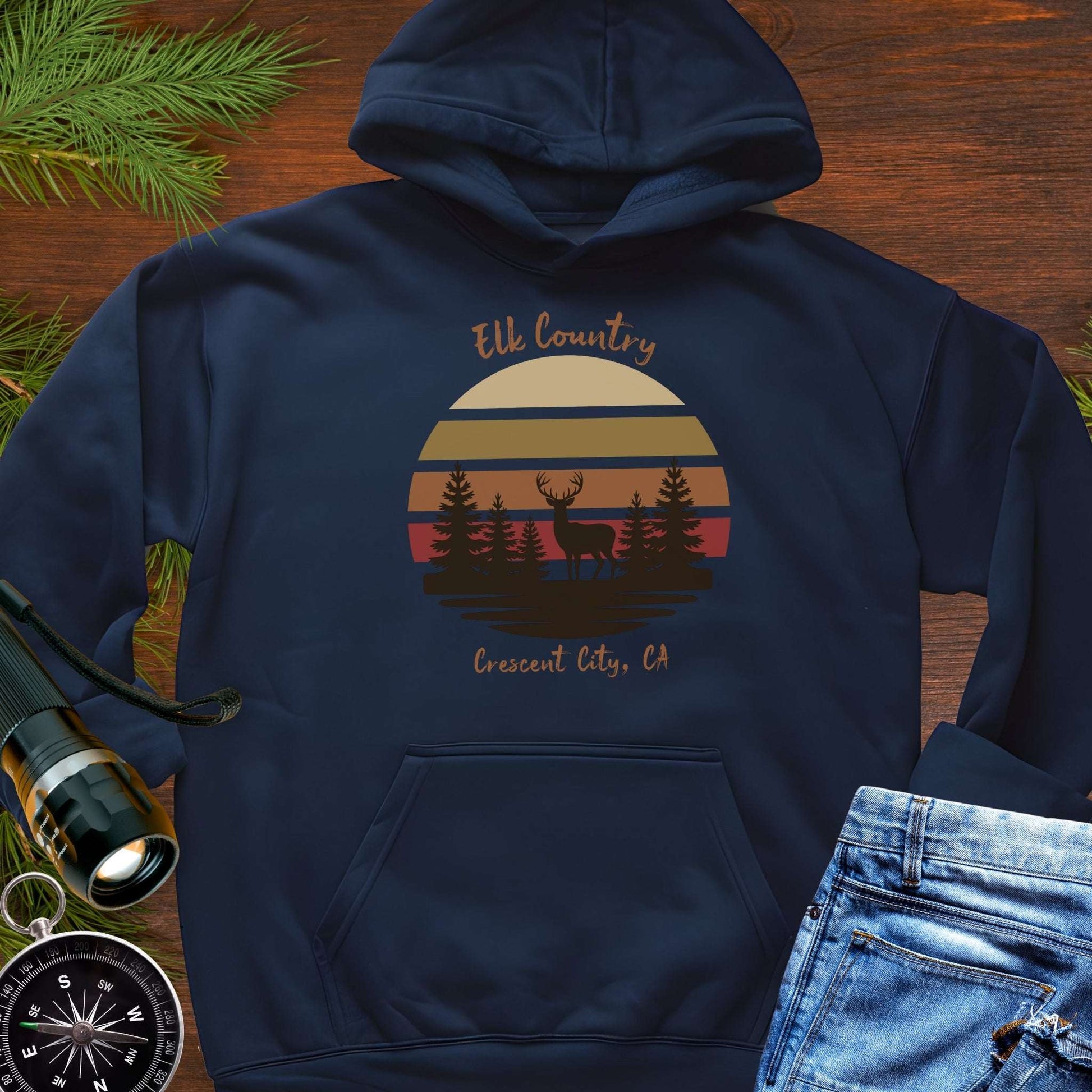 Navy blue hoodie with 'Elk Country' with retro sunset and silhouette of trees and elk design with Crescent City, CA underneath.