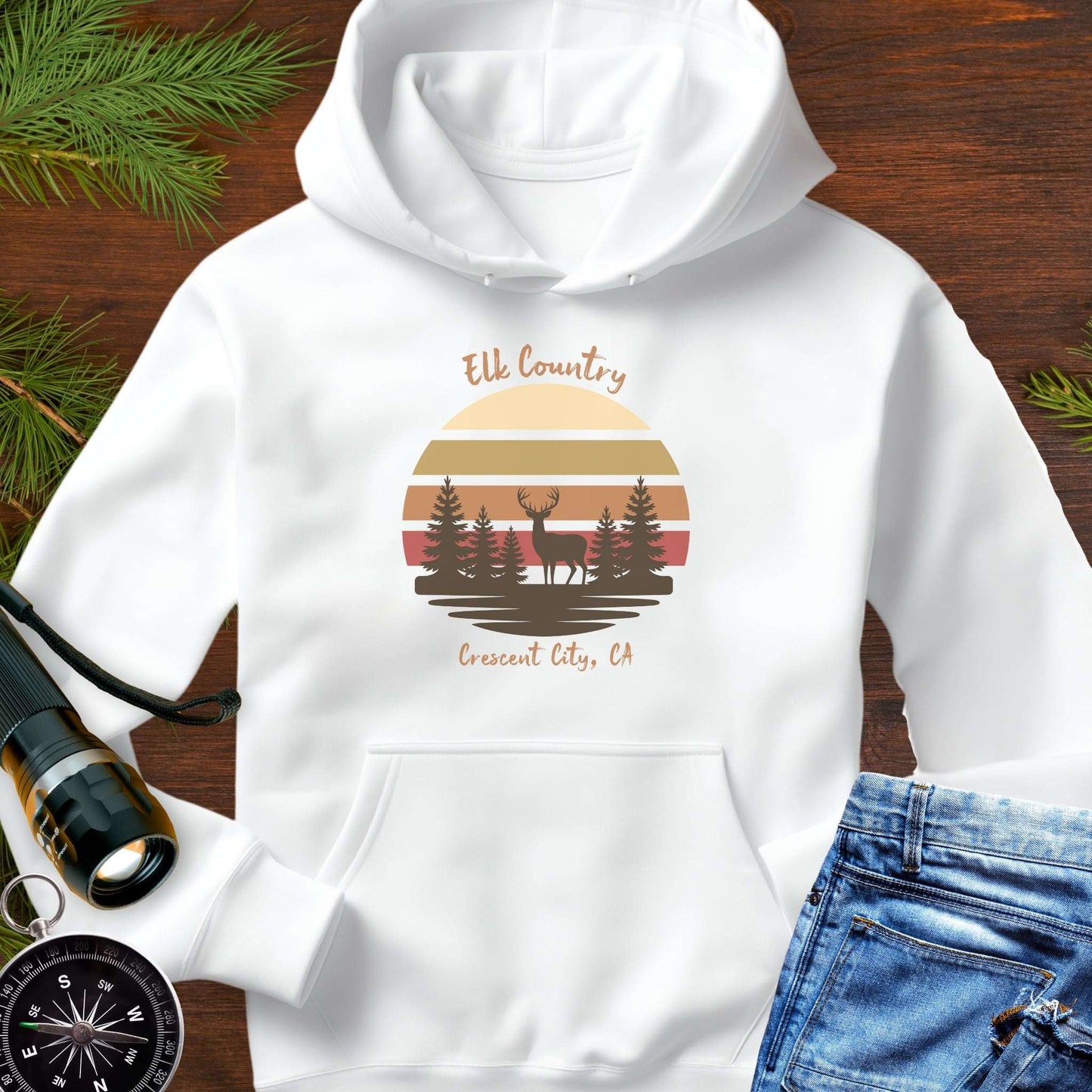 White hoodie with 'Elk Country' with retro sunset and silhouette of trees and elk design with Crescent City, CA underneath.