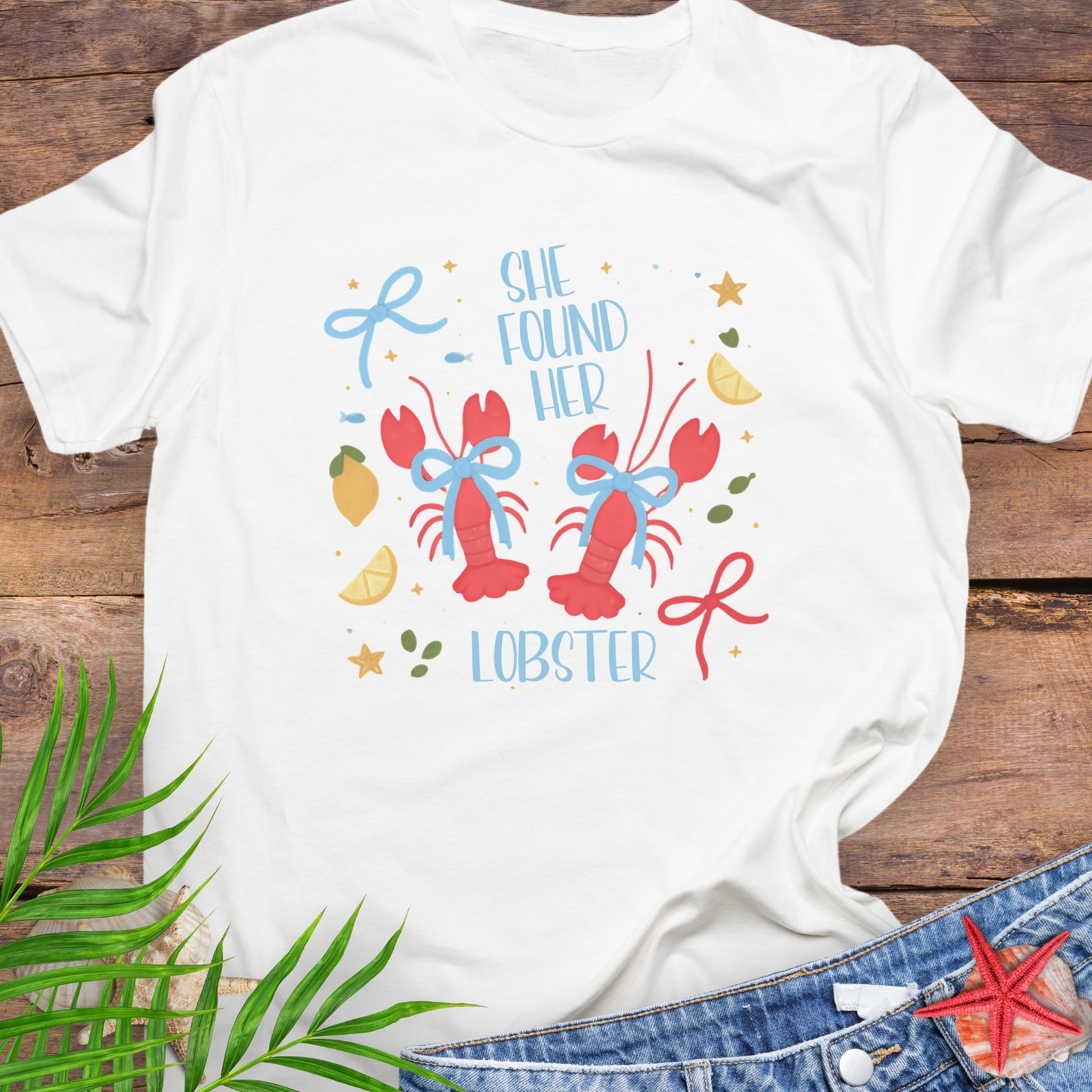 White t-shirt with colorful graphic and text 'She Found Her Lobster'.