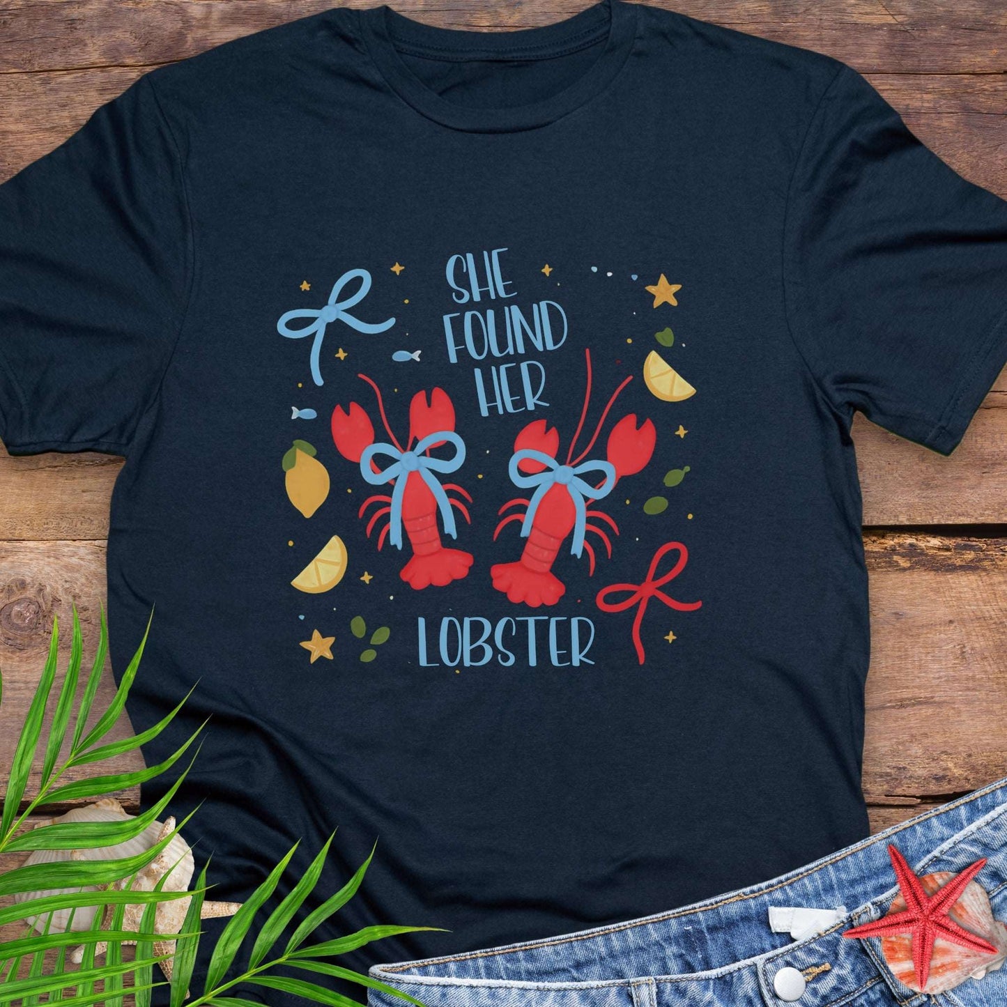 Navy Blue T-shirt with two lobsters and blue bows that says She Found Her Lobster.
