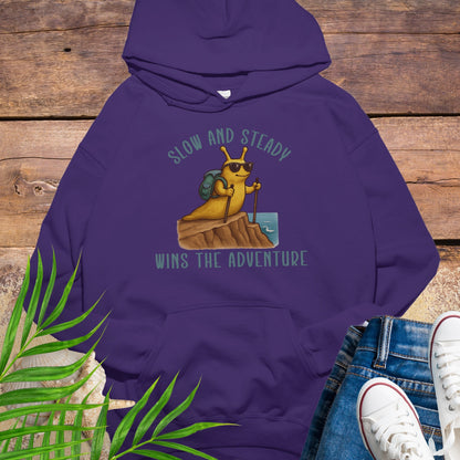 Purple hoodie with a bee graphic and text on a wooden surface