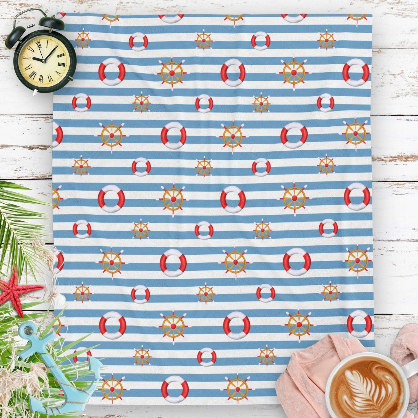 Nautical-themed velveteen blanket with stripes, life buoys, and ship wheels.