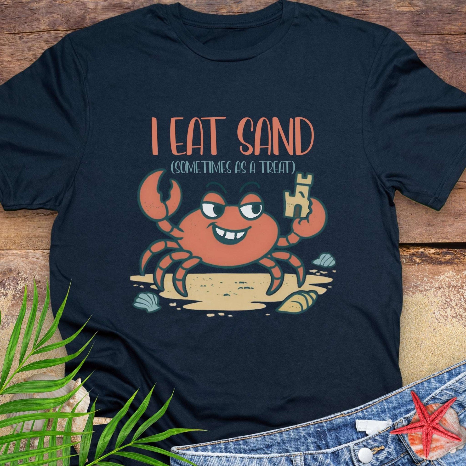 Navy blue t-shirt with a cartoon crab design and text 'I Eat Sand (Sometimes as a Treat)'.