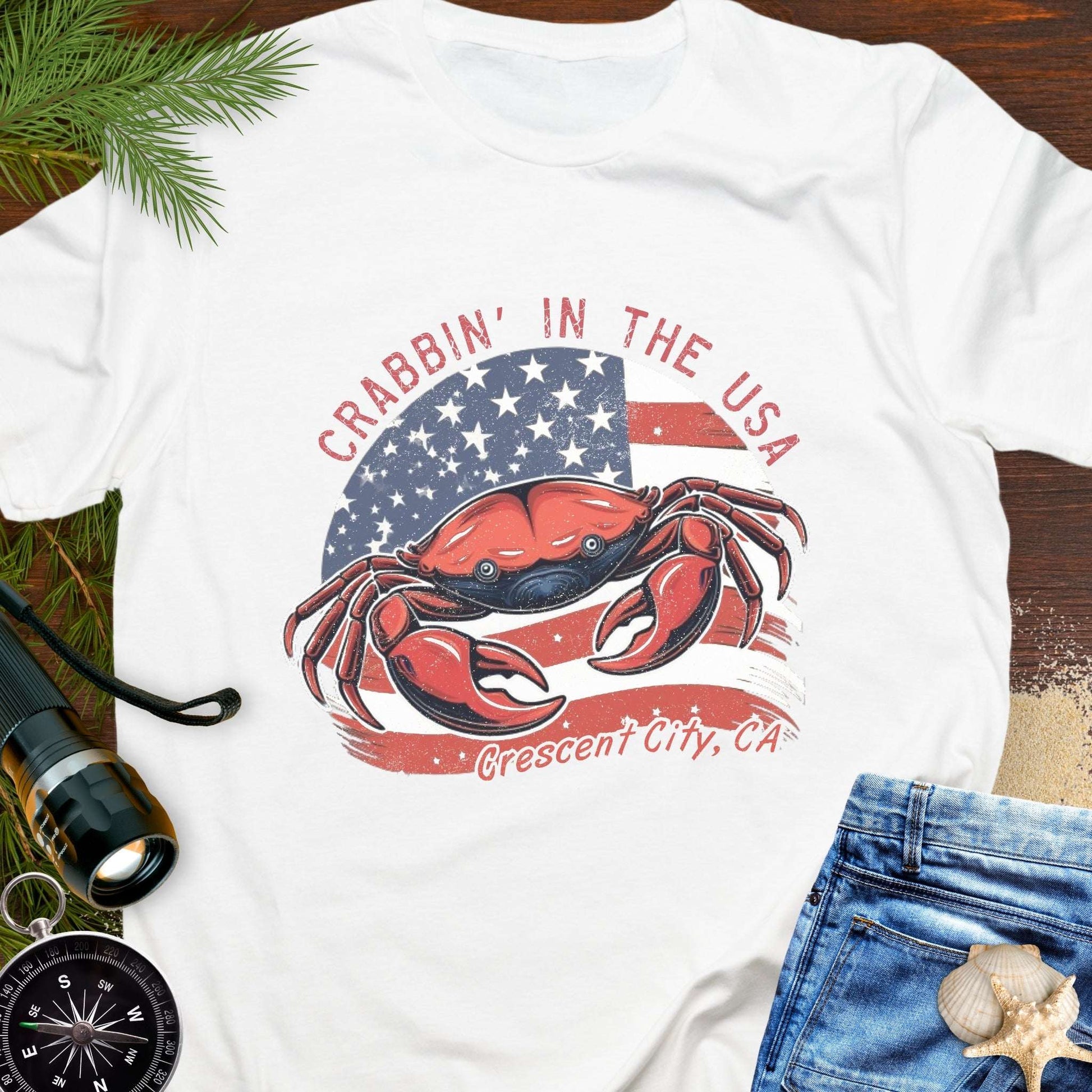 White t-shirt with a crab and American flag design and text 'Crabbin' in the USA – Crescent City, CA'. 