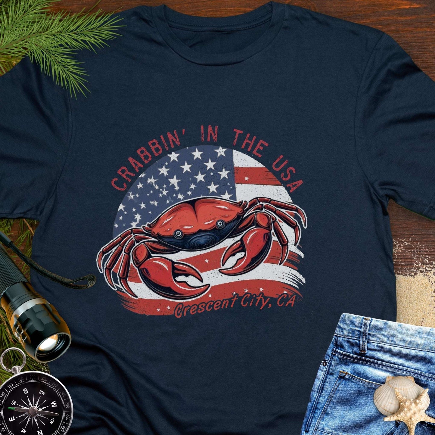 Navy blue t-shirt with a crab and American flag design and text 'Crabbin' in the USA – Crescent City, CA'. 
