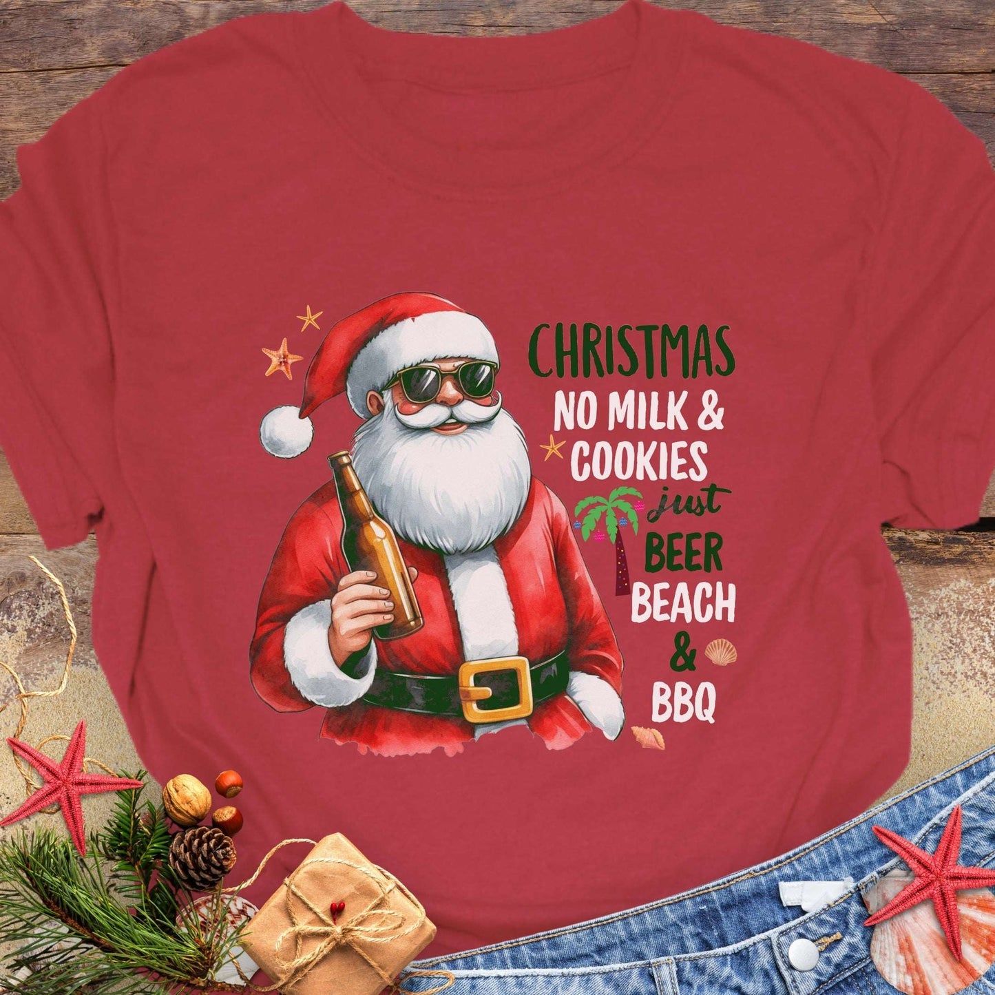 Red t-shirt with a graphic of Santa Claus holding a beer, text 'Christmas No Milk & Cookies Just Beer Beach & BBQ'.