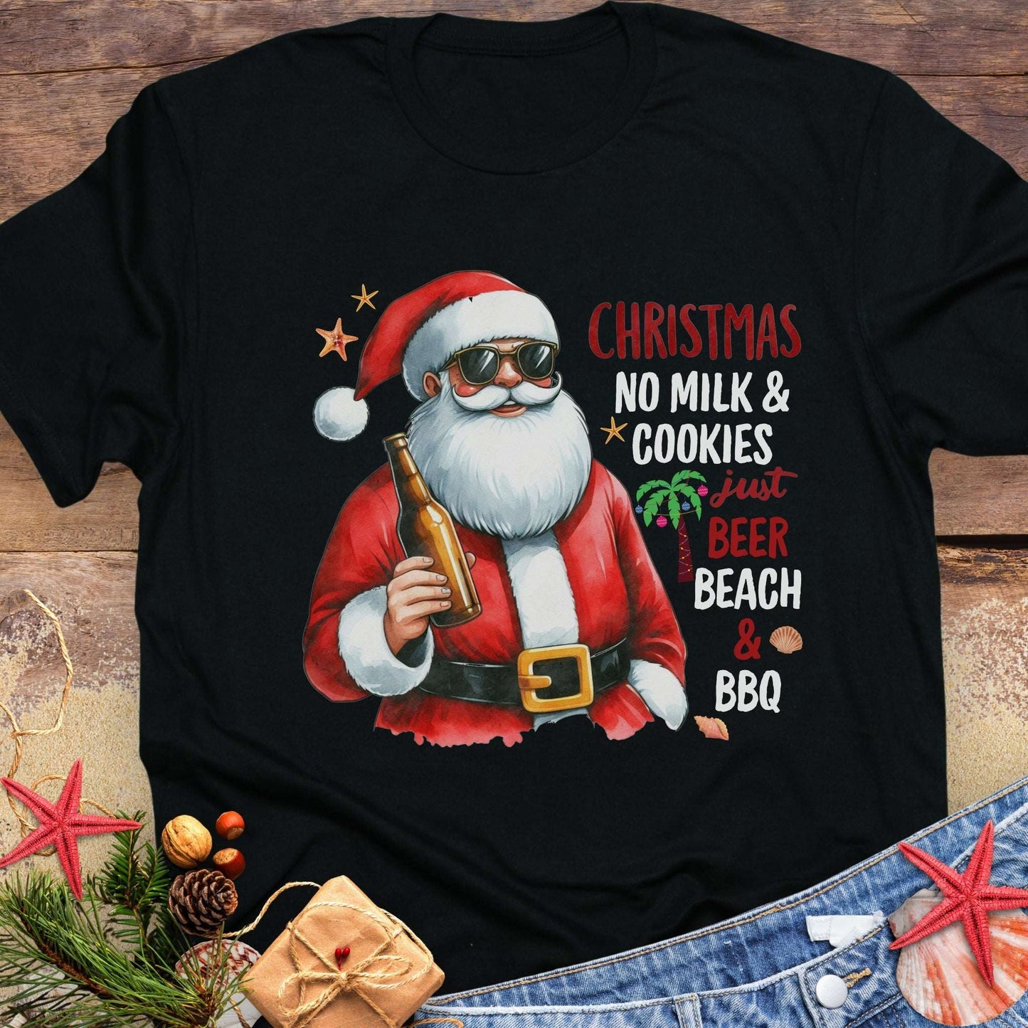 Black t-shirt with a graphic of Santa Claus holding a beer, text 'Christmas No Milk & Cookies Just Beer Beach & BBQ'.