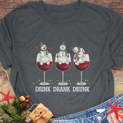 Gray T-shirt with three snowmen sitting inside large wine glasses, raising smaller glasses above the text “DRINK DRANK DRUNK.