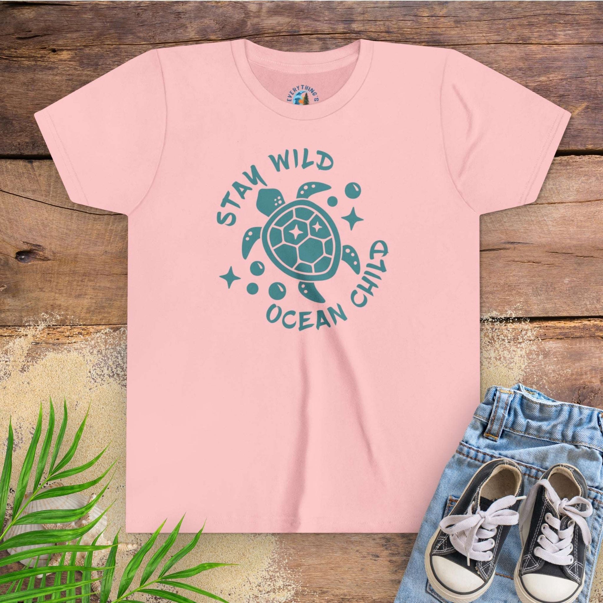 Pink t-shirt with sea turtle graphic and text stay wild ocean child.
