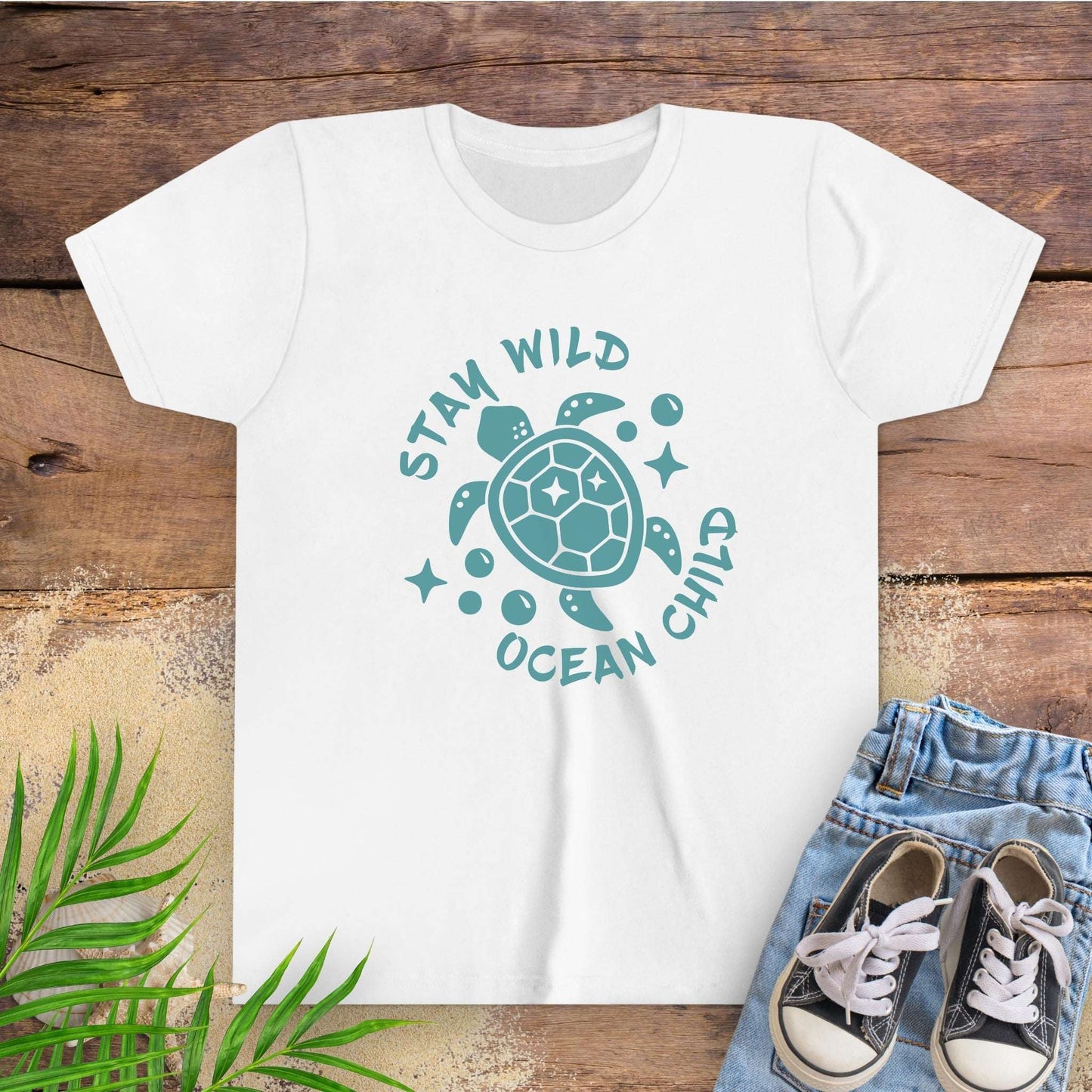White t-shirt with sea turtle graphic and text stay wild ocean child.