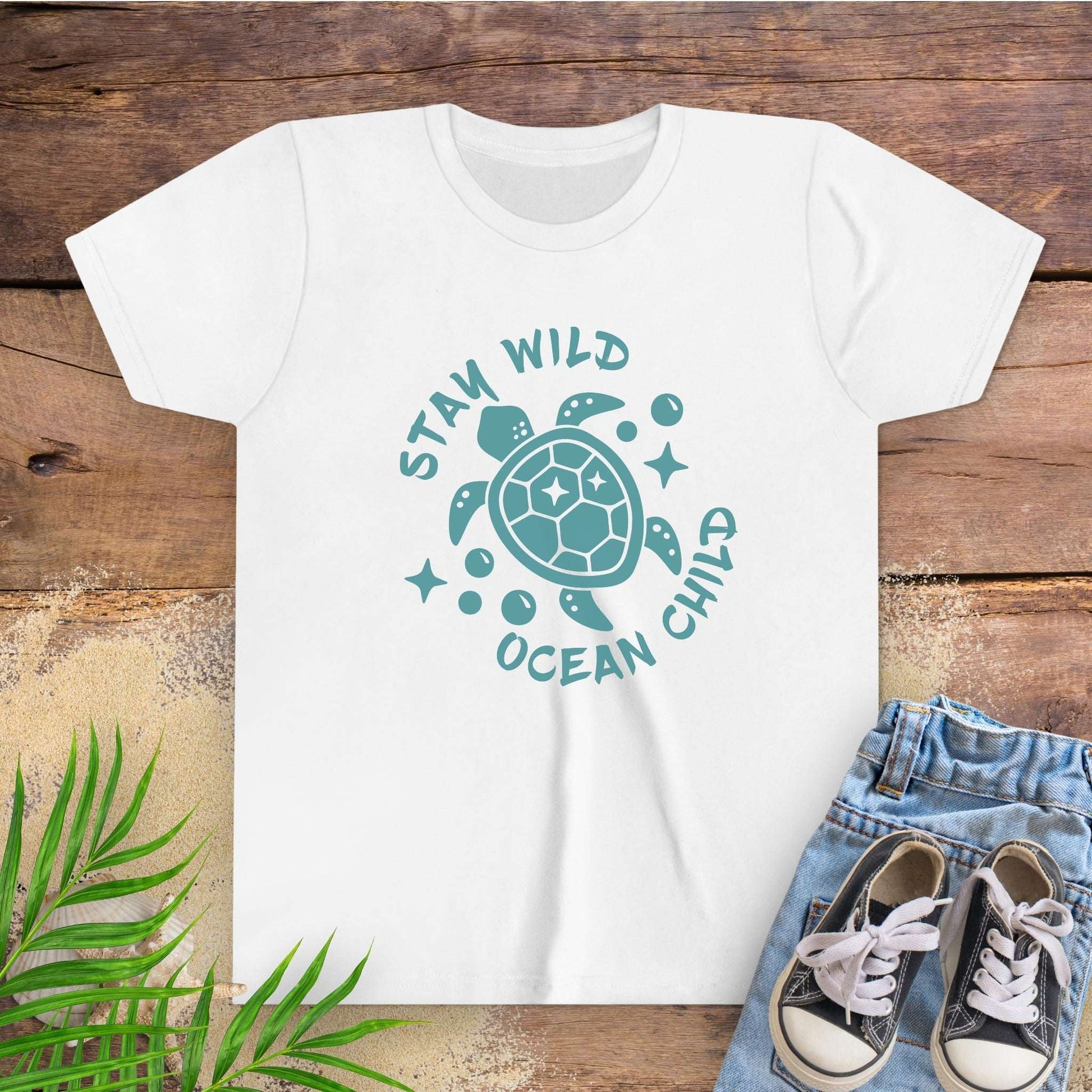 White t-shirt with sea turtle graphic and text stay wild ocean child.