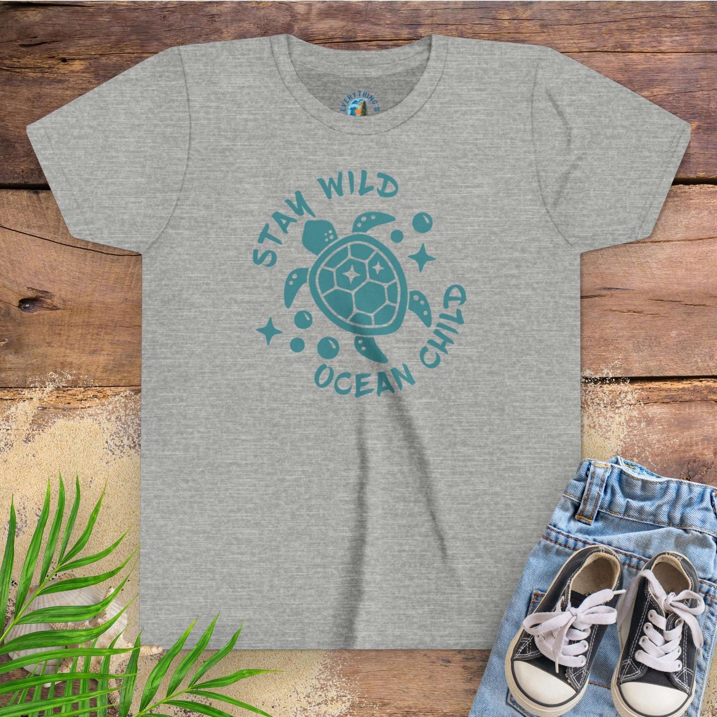 Gray t-shirt with sea turtle graphic and text stay wild ocean child.