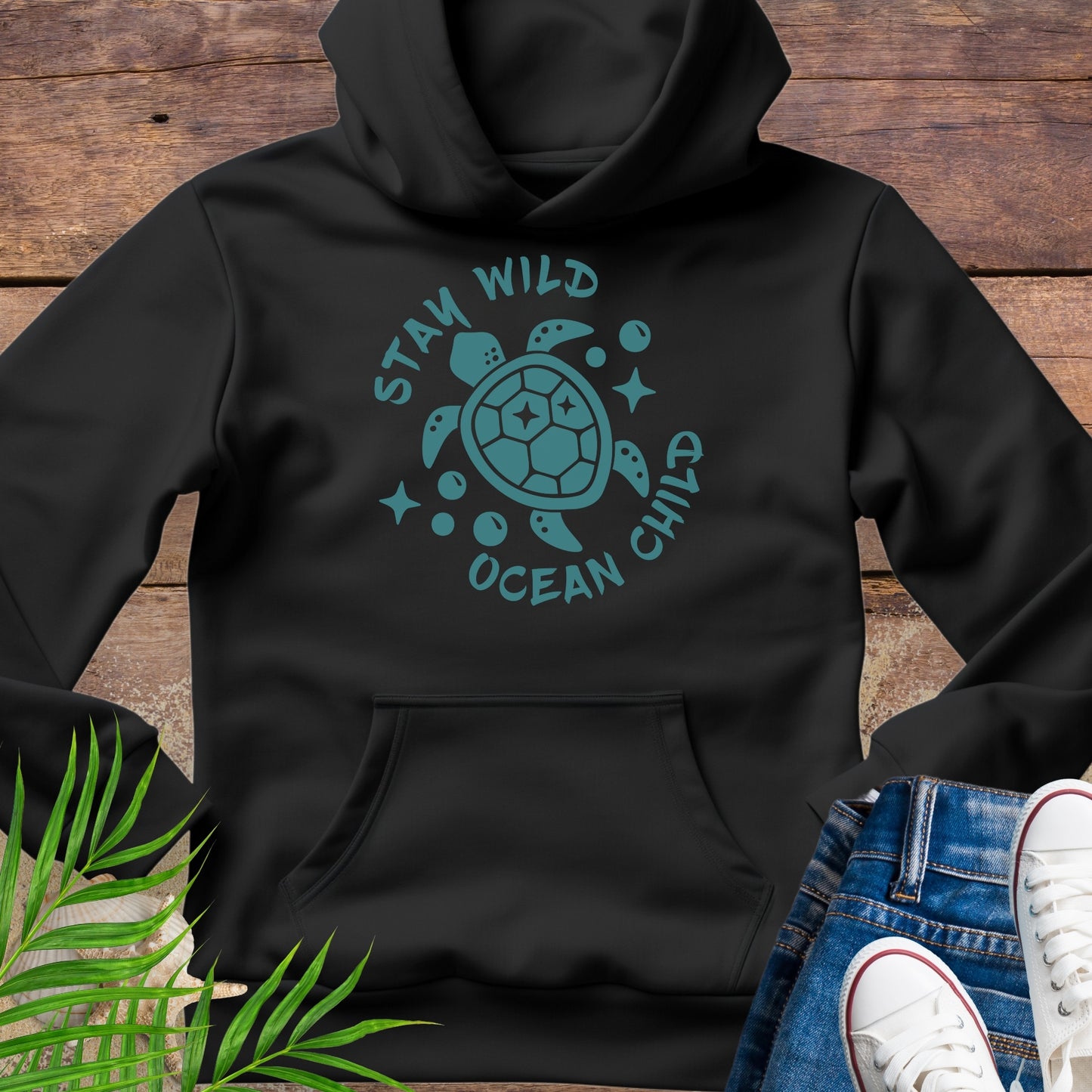 Black hoodie with a sea turtle design and text Stay Wild Ocean Child.
