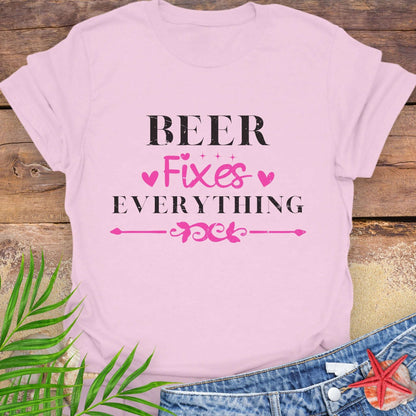 Pink unisex t-shirt with “Beer Fixes Everything” text and decorative pink hearts and scroll graphic.