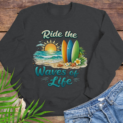 Dark Heather Gray crewneck sweatshirt with inspirational Ride the Waves of Life beach design, showing surfboards, ocean sunset, palm leaves, and sand.