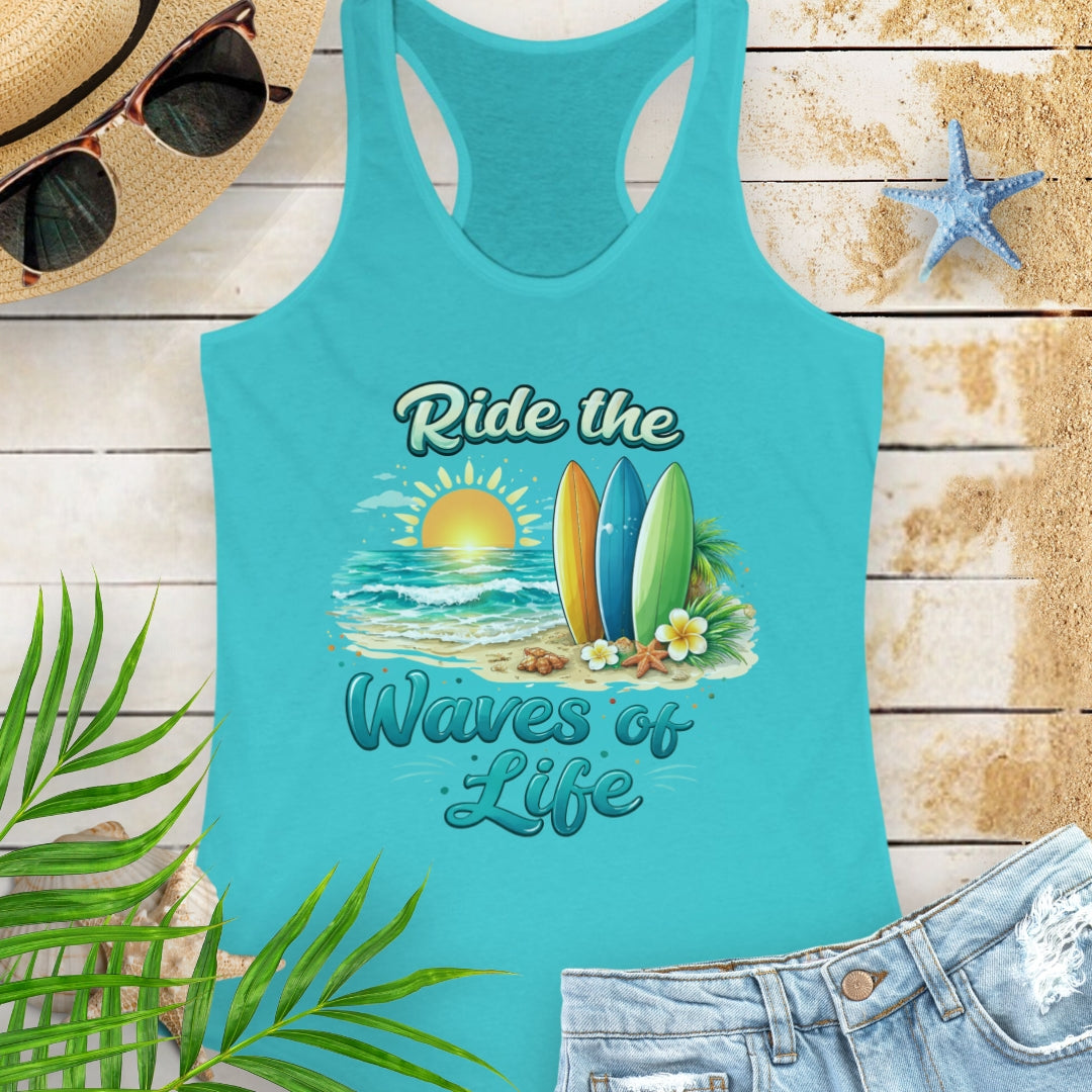 Turquoise Women's racerback tank top with a scooped neckline, side seams for a fitted silhouette, and lightweight cotton-poly fabric. Features the 'Ride the Waves of Life' beach graphic on the front.