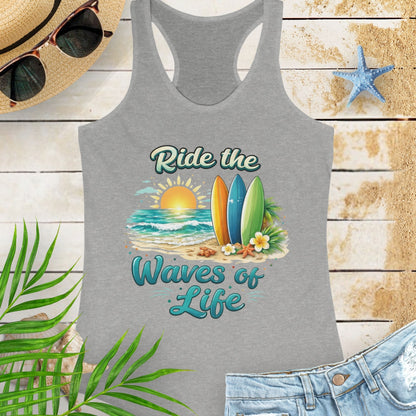 Gray Women's racerback tank top with a scooped neckline, side seams for a fitted silhouette, and lightweight cotton-poly fabric. Features the 'Ride the Waves of Life' beach graphic on the front.