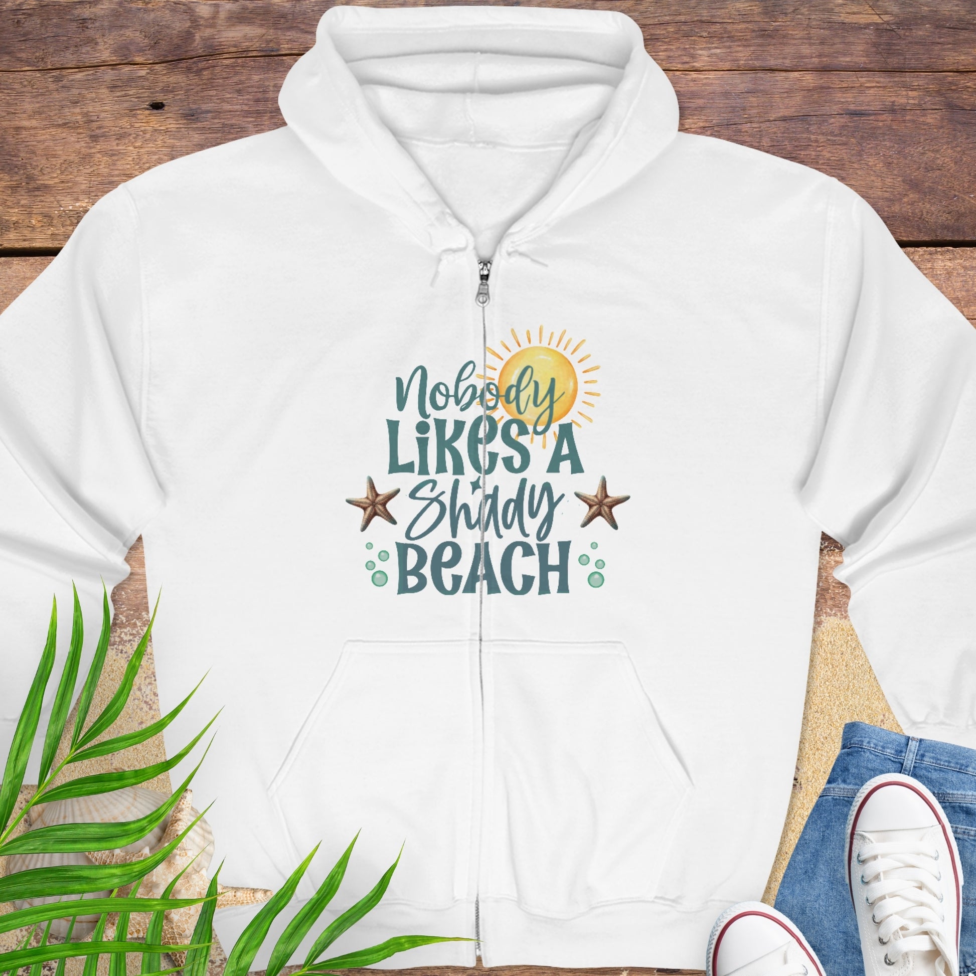 White hoodie with beach-themed graphics and text Nobody Likes a Shady Beach.