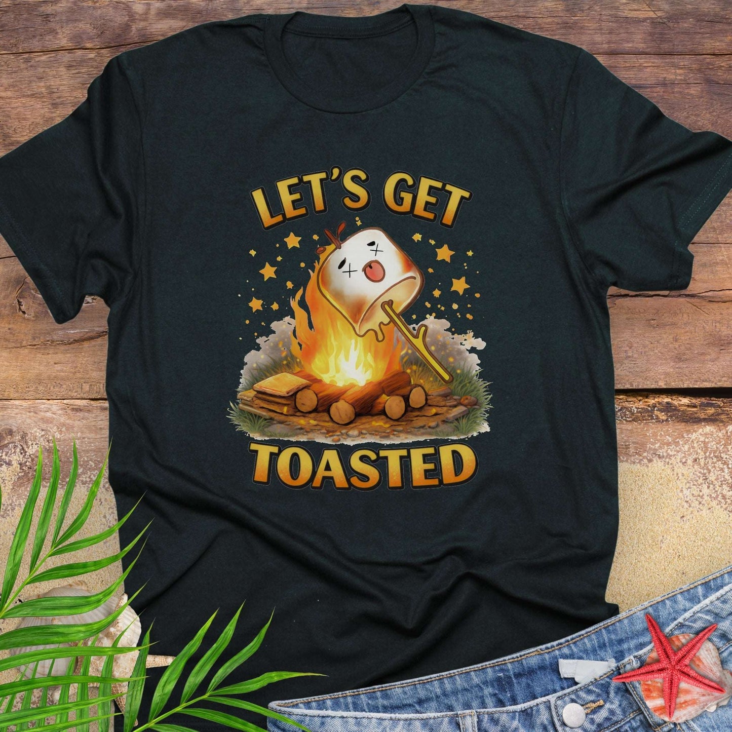 Black t-shirt with a graphic of a marshmallow over a campfire and text 'Let's Get Toasted.