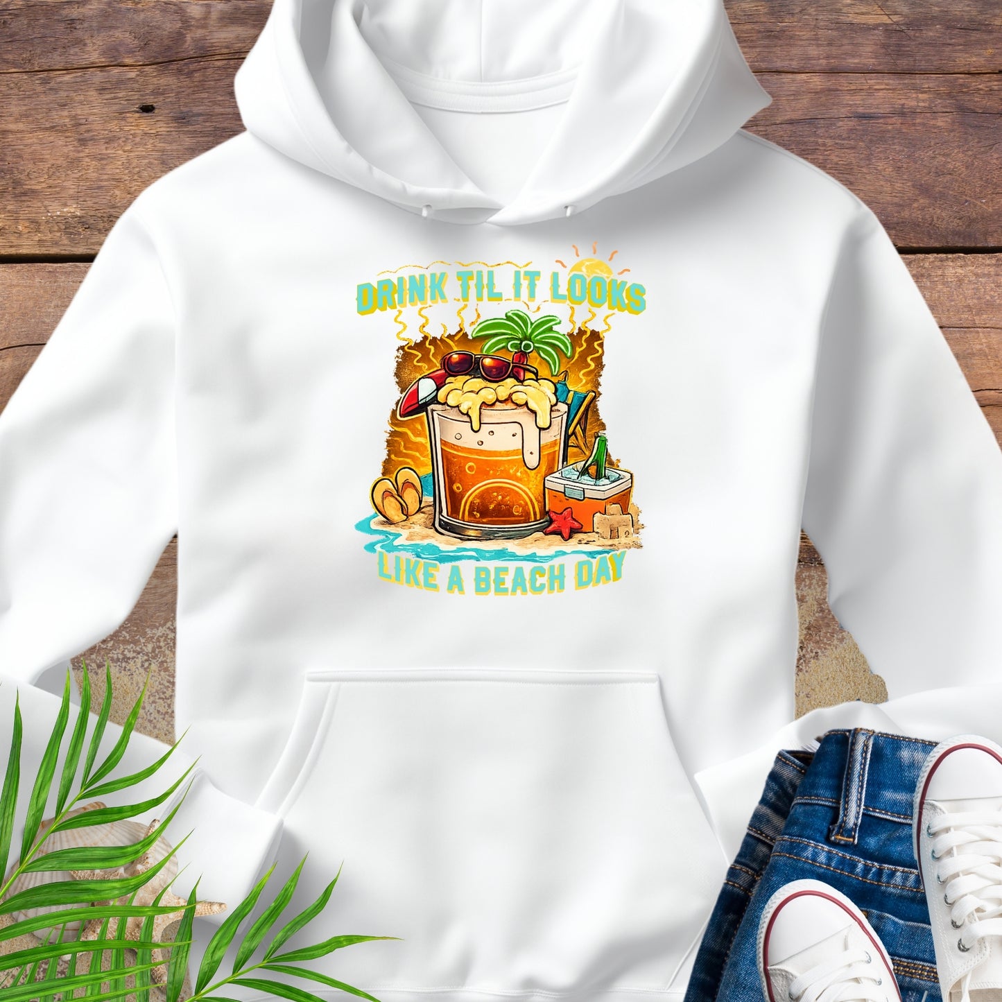 White pullover hoodie with a tropical cartoon beer mug, palm tree, sunglasses, and the text “Drink Til It Looks Like a Beach Day” in vibrant summer colors.