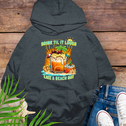 Dark gray pullover hoodie with a tropical cartoon beer mug, palm tree, sunglasses, and the text “Drink Til It Looks Like a Beach Day” in vibrant summer colors.