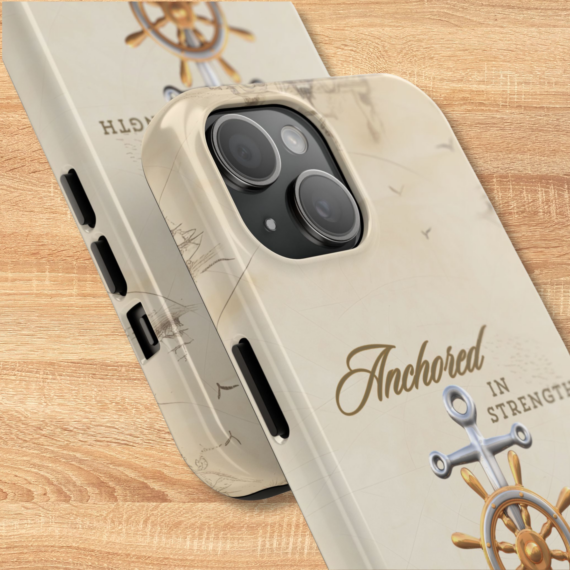 Phone case with 'Anchored in Strength' text and ship wheel design on a wooden surface