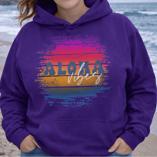 Woman wearing a purple hoodie with 'Aloha Vibes' design on a beach