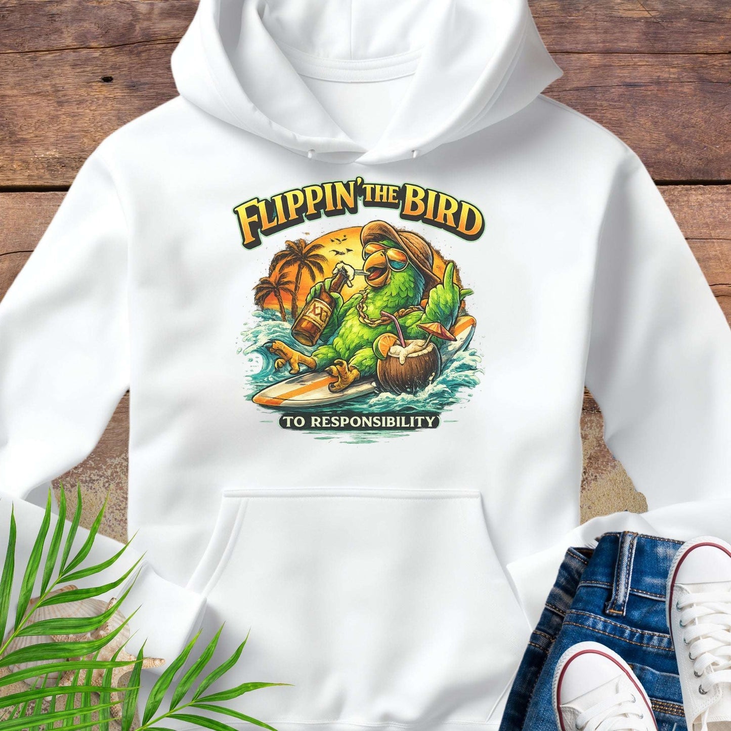 White tropical graphic hoodie featuring a green parrot surfing with sunglasses, holding a beer, with coconut drink and sunset palms; text reads “Flippin’ the Bird (to responsibility)”.