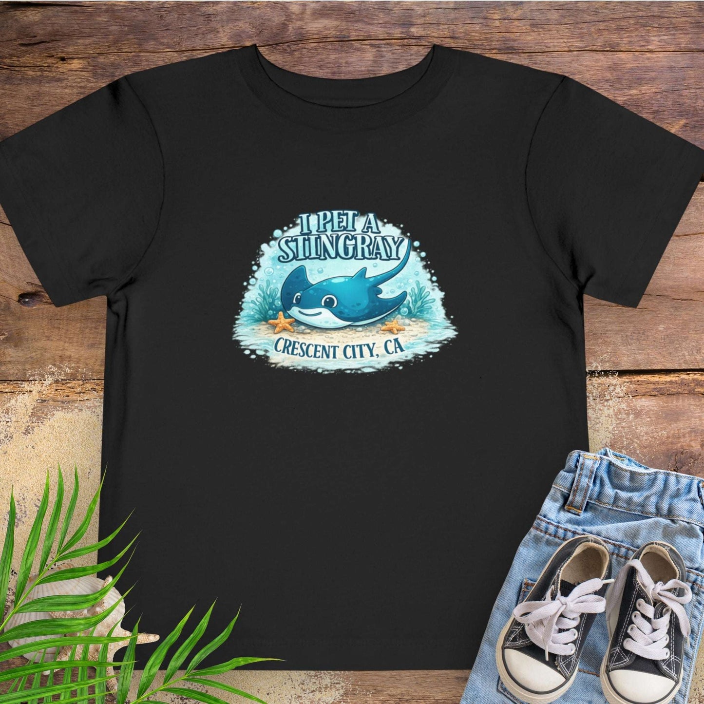 Black t-shirt with a stingray graphic and text 'I Pet a Stingray Crescent City, CA'.