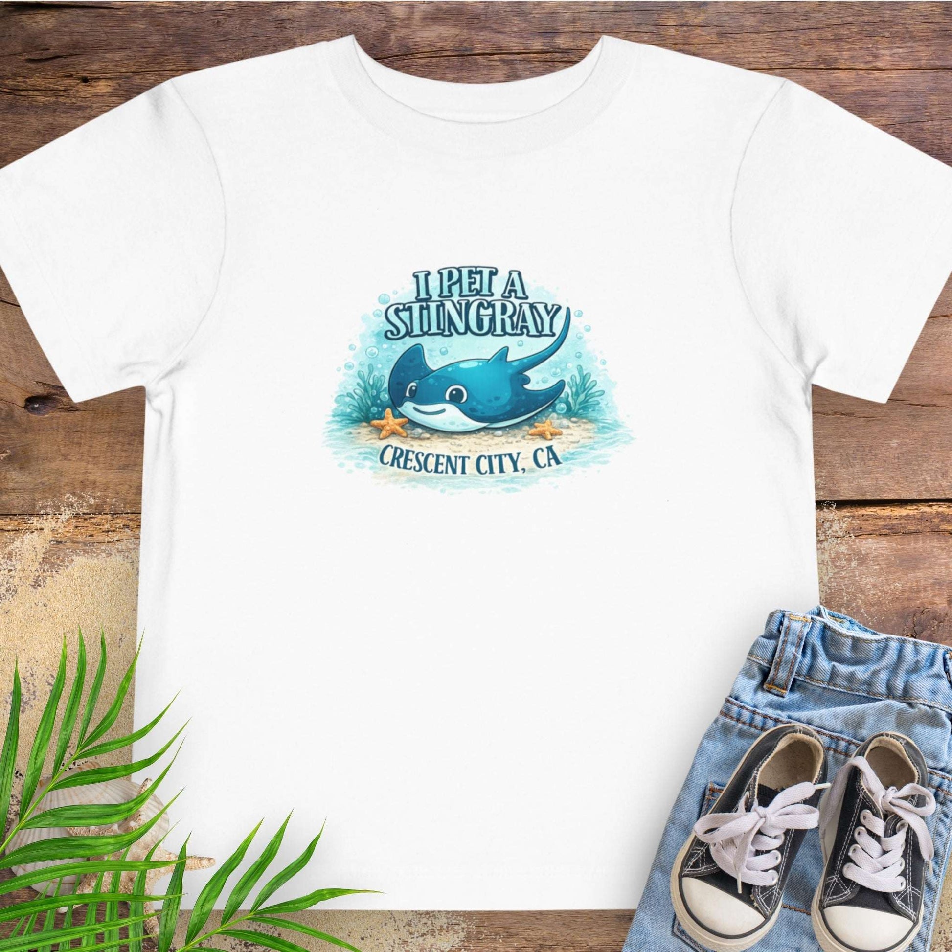 White t-shirt with a stingray graphic and text 'I Pet a Stingray Crescent City, CA'.