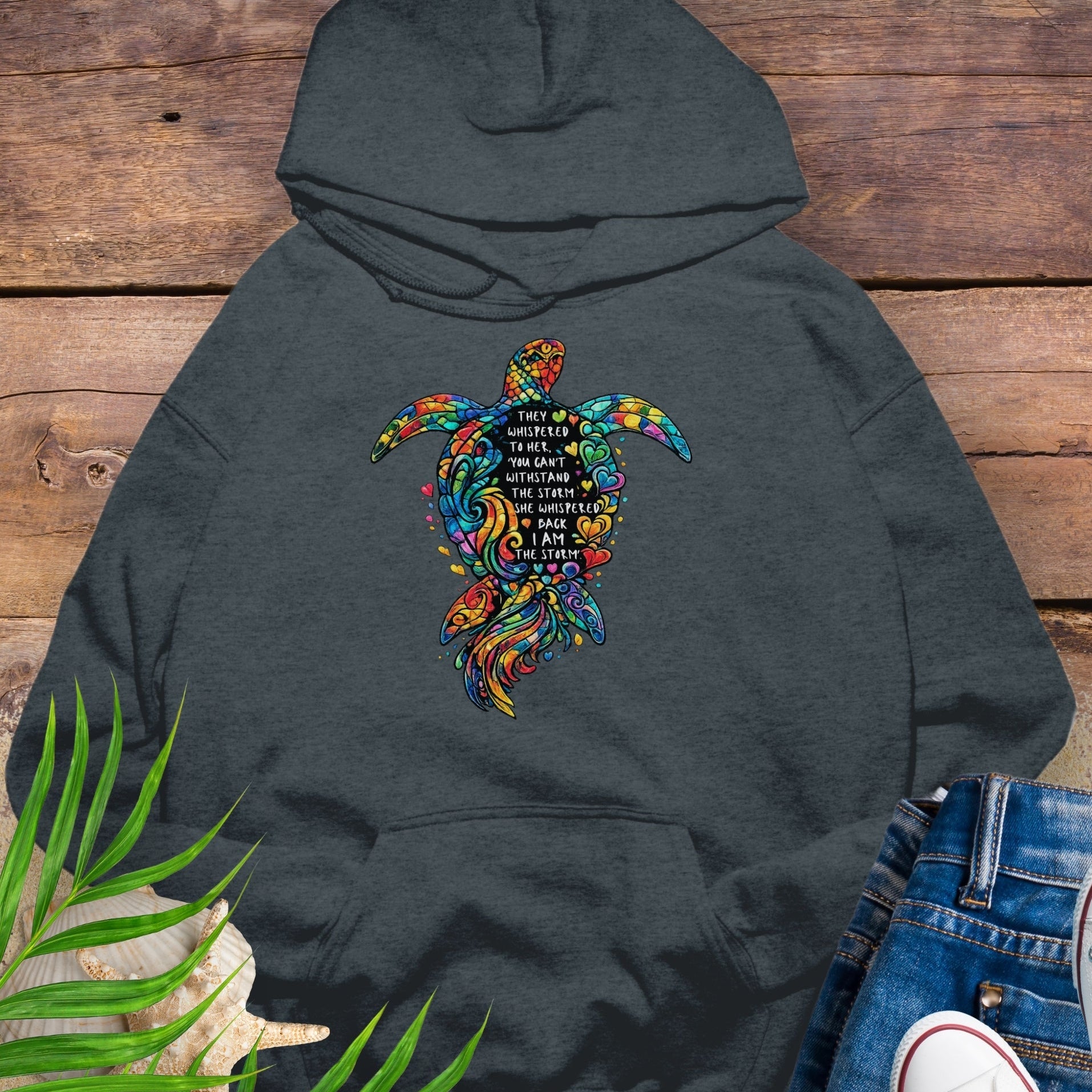 Dark gray Unisex hoodie featuring sea turtle design with “I Am the Storm” inspirational quote in ocean colors.