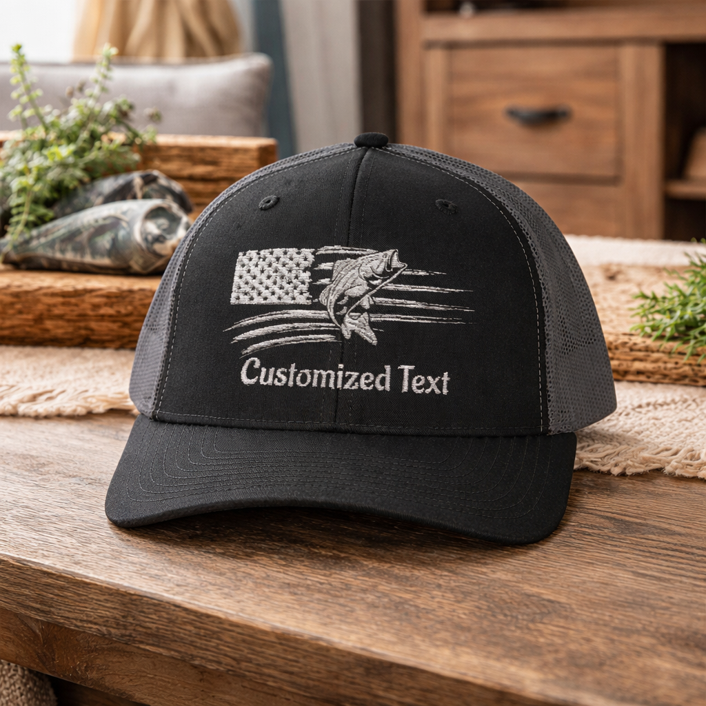 Black cap with embroidered fish over the US Flag design and 'Customized Text' on a wooden surface.