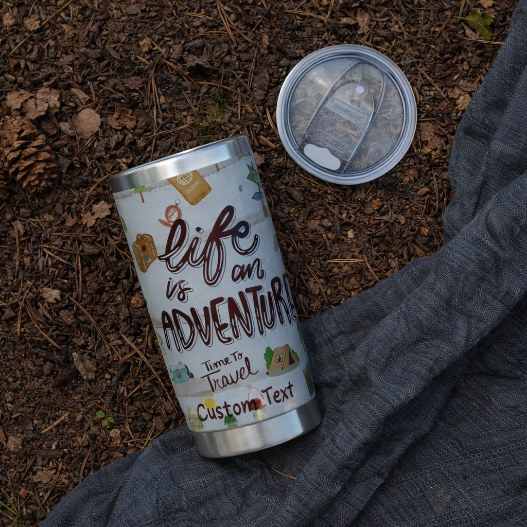 Silver tumbler with 'Life is an Adventure' text on a natural background