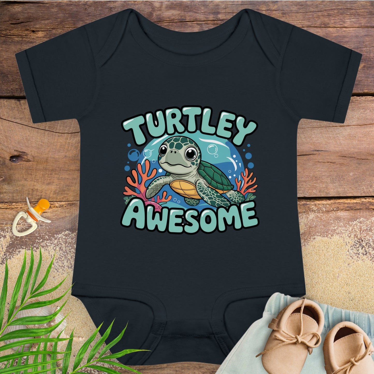 Black baby onesie with a turtle design and 'Turtley Awesome' text on a wooden surface.