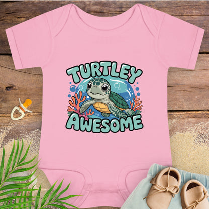 Pink baby onesie with a turtle graphic and 'TURTLEY AWESOME' text on a wooden surface.