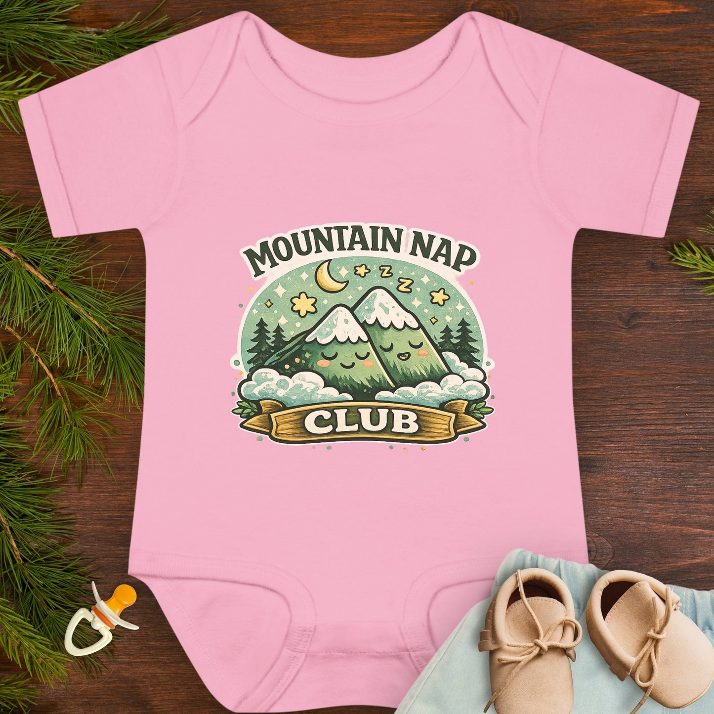 Pink baby onesie with 'Mountain Nap Club' design with cartoon mountains.