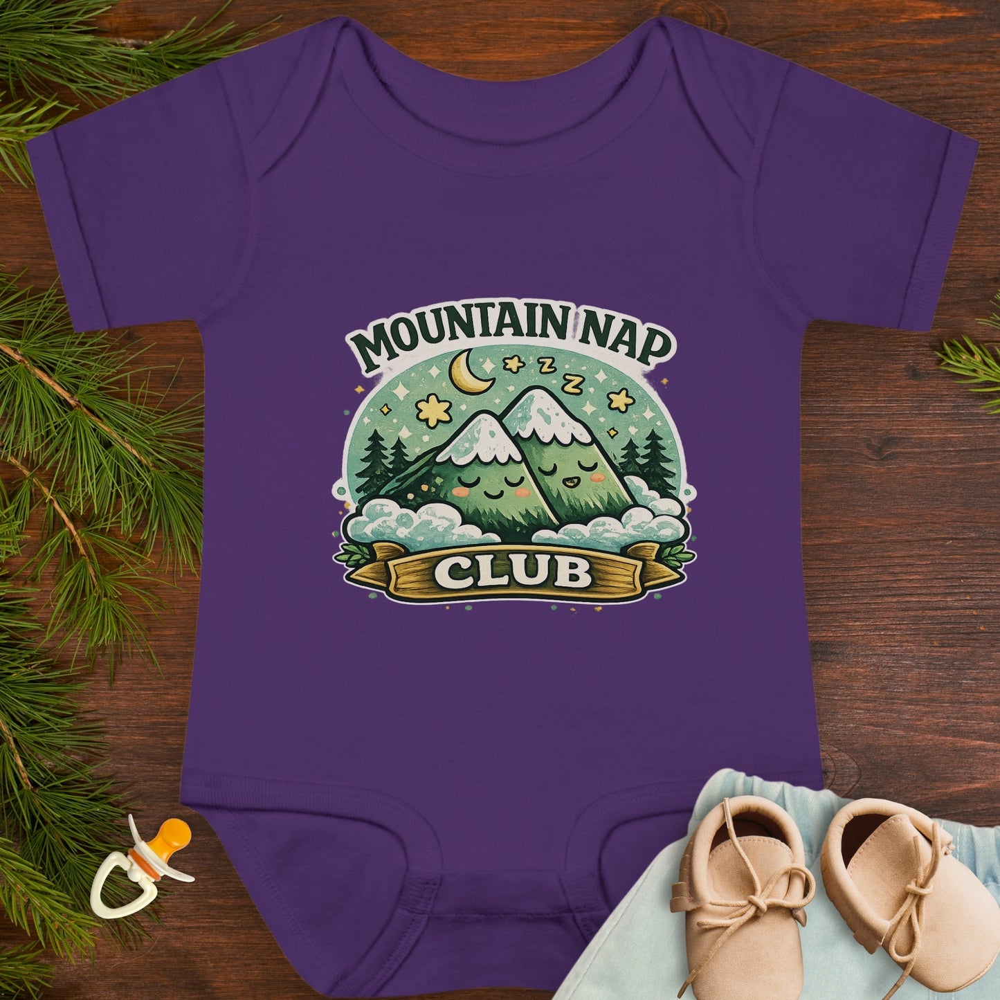 Purple baby onesie with 'Mountain Nap Club' design with cartoon mountains.
