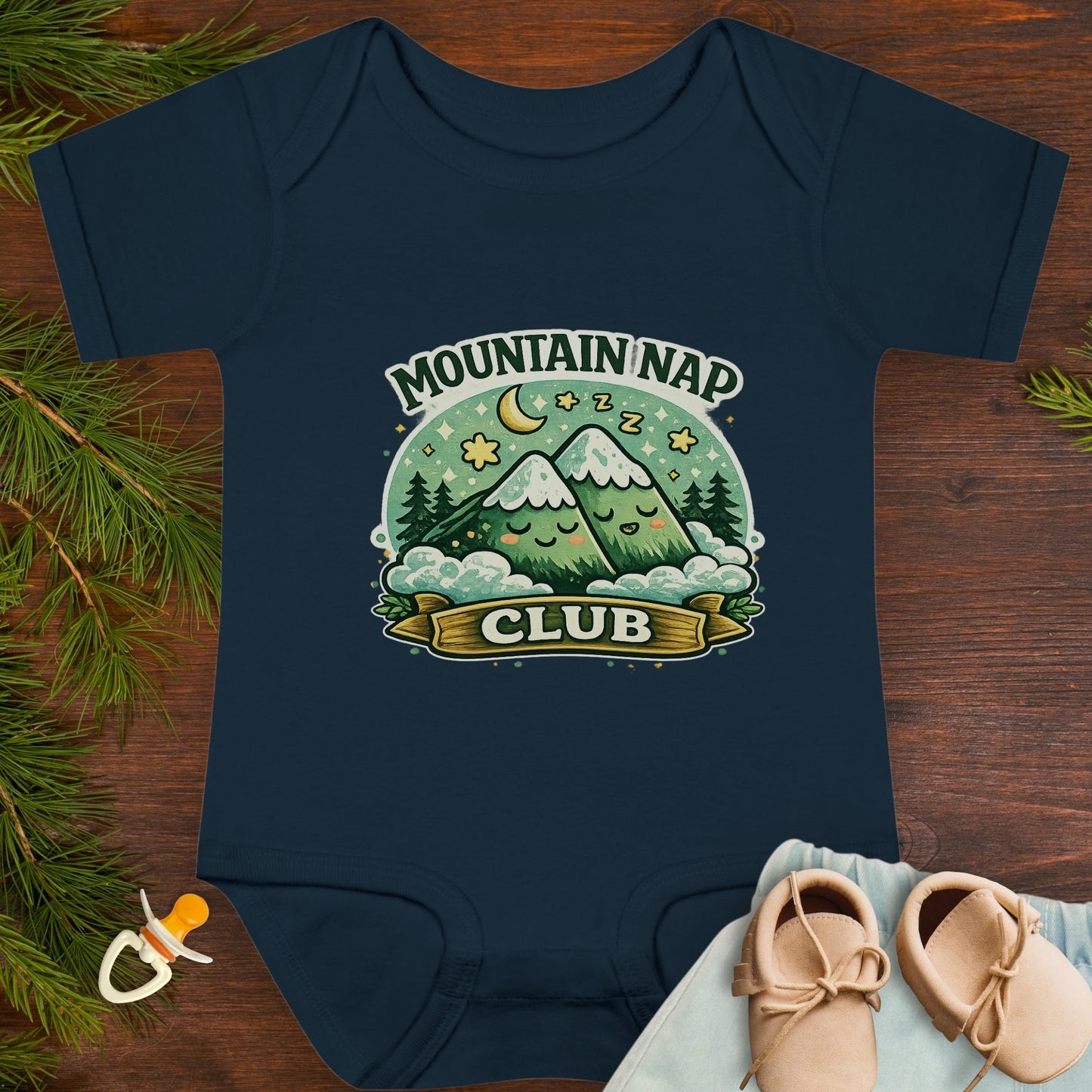 Navy blue baby onesie with 'Mountain Nap Club' design with cartoon mountains.