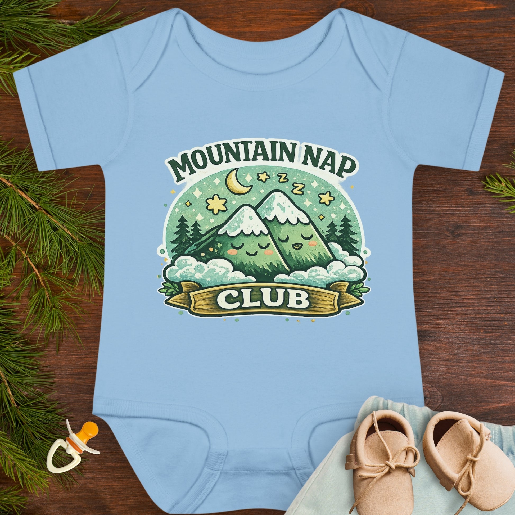 Baby onesie with 'Mountain Nap Club' design with cartoon mountains.
