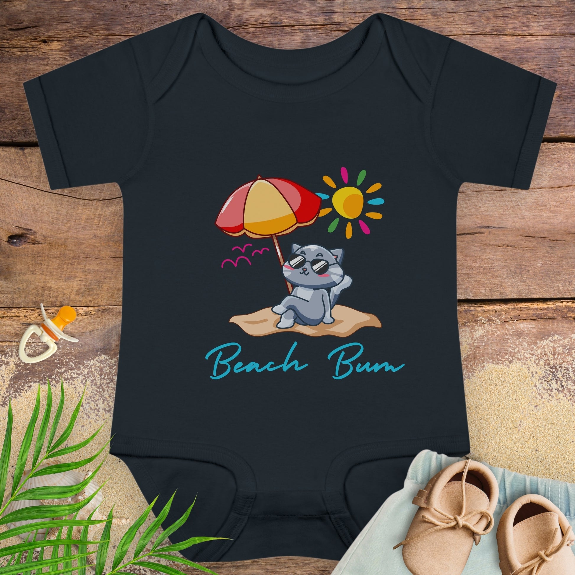 Black baby beach bum onesie with a beach-themed design featuring a cat, umbrella, and sun. 