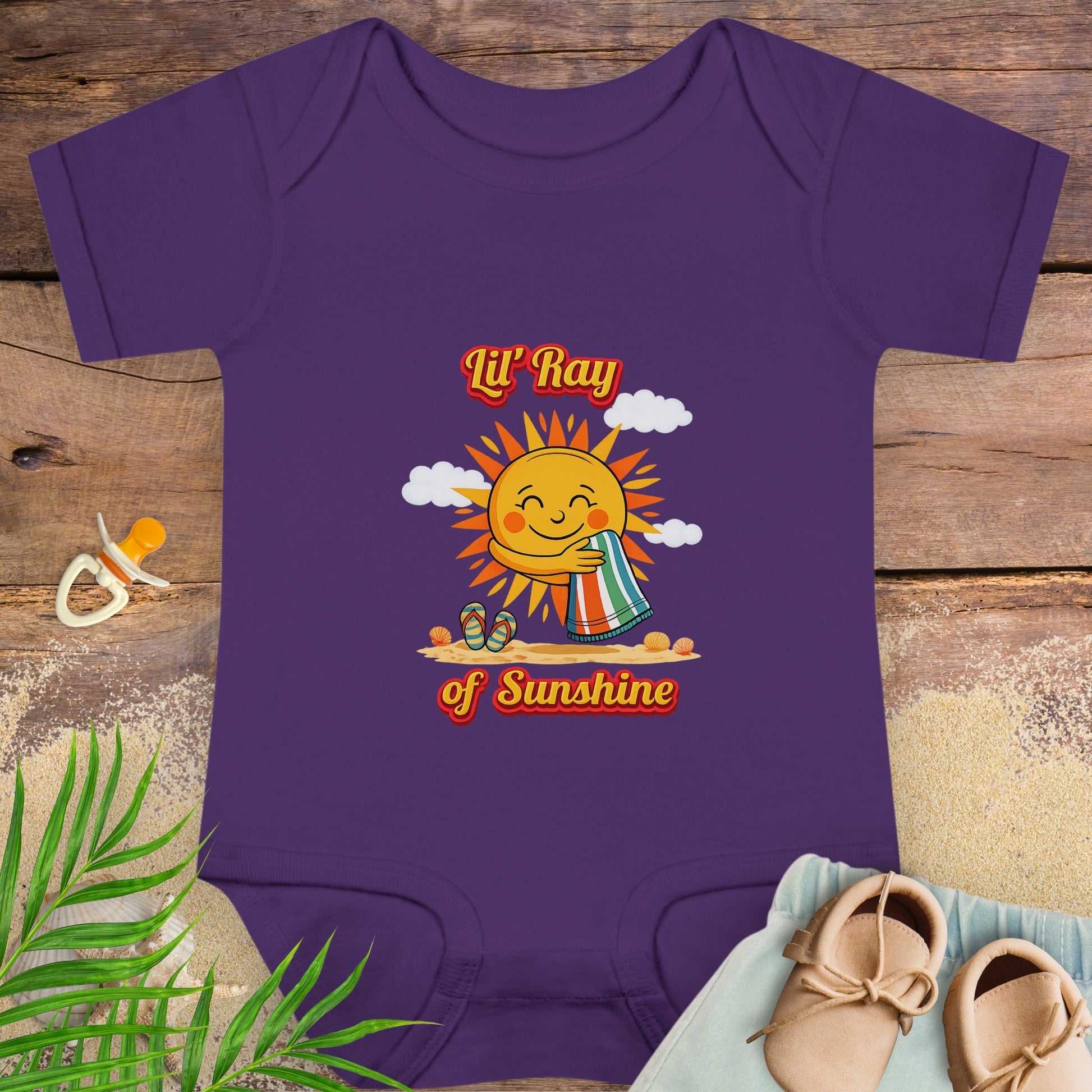 Purple baby onesie onesie with smiling sun beach graphic and text “Lil’ Ray of Sunshine.