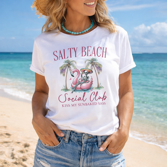 Woman wearing a 'Salty Beach Social Club' t-shirt on a beach