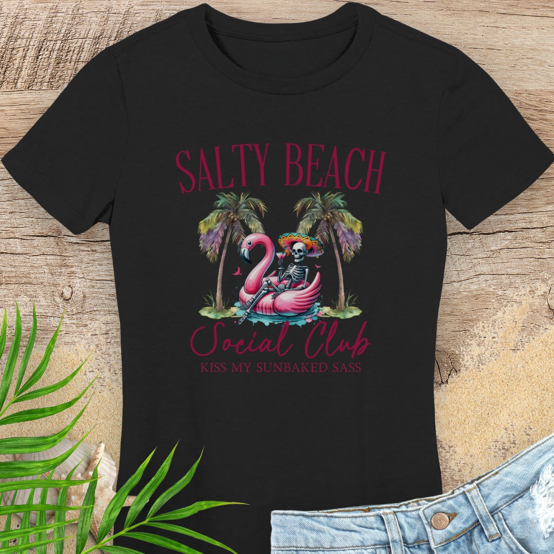 Black t-shirt with 'Salty Beach Social Club' design featuring a skeleton and flamingo on a wooden surface.