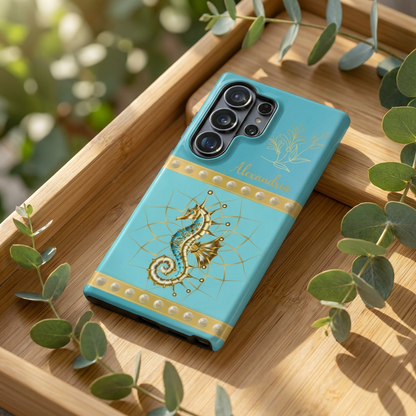 Turquoise Blue phone case with a golden seahorse design on a wooden surface with green leaves.