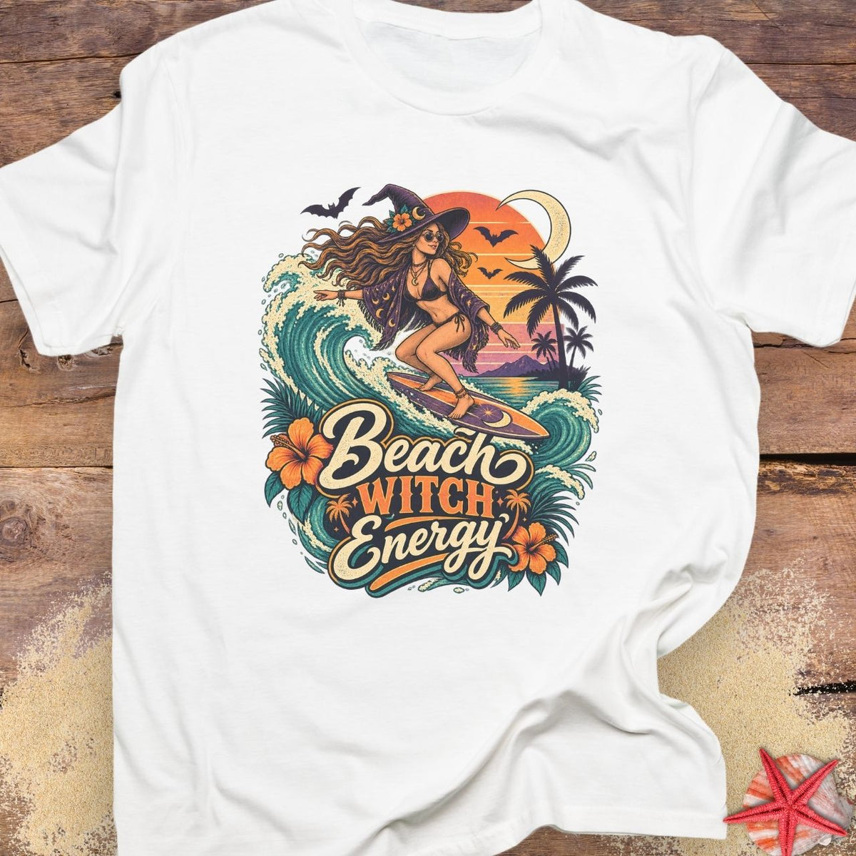 White unisex t-shirt with “Beach Witch Energy” text, a witchy surfer girl, ocean wave, sunset, crescent moon, bats, palm trees, and tropical flowers.
