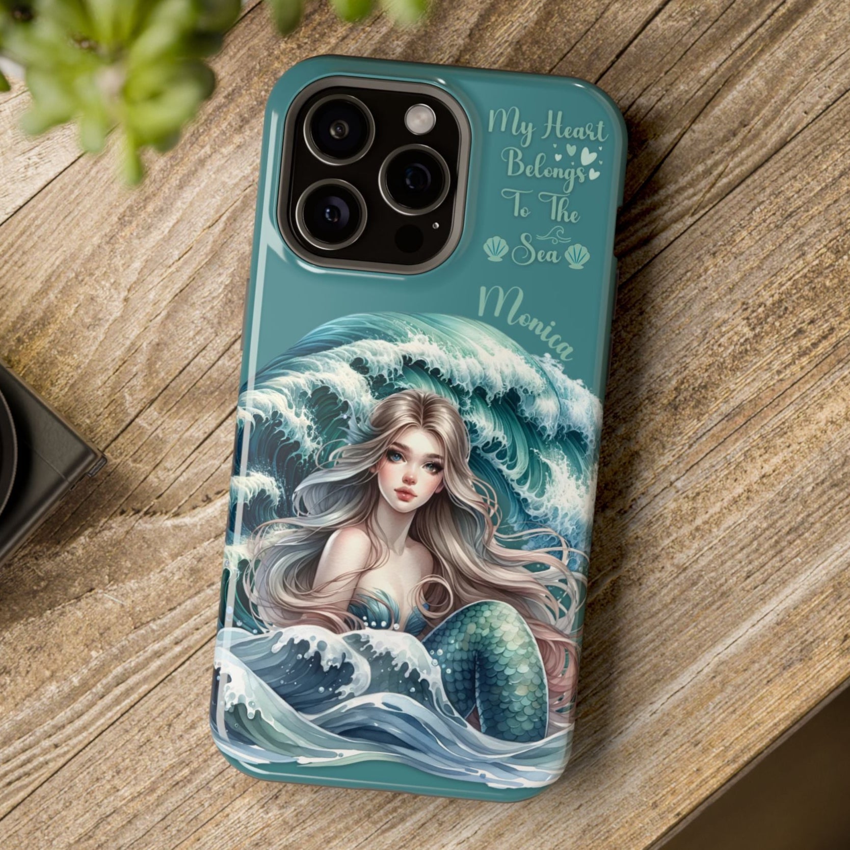 Phone case with mermaid design on a wooden surface