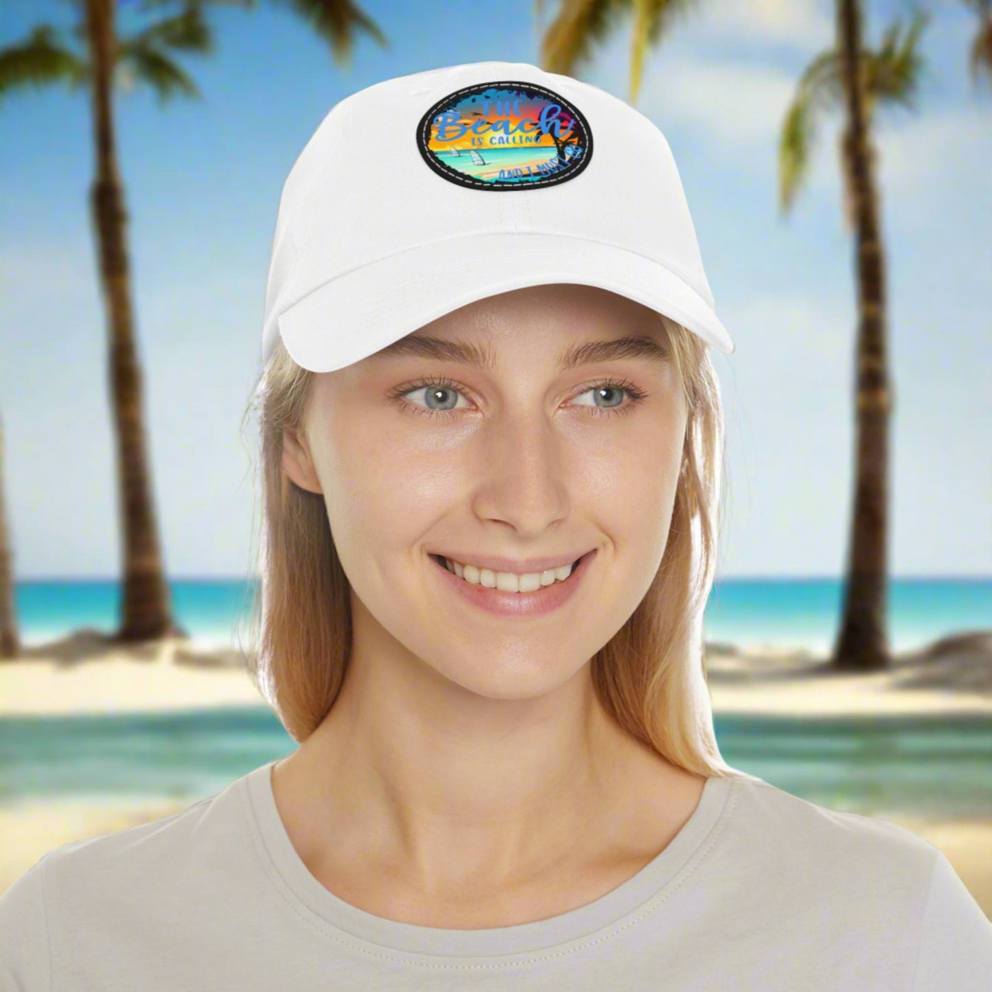 White hat with a leather patch with picture of beach scene and text The beach is calling and I must go.