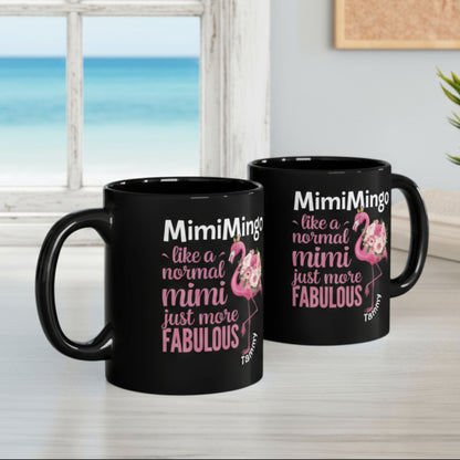 Two black mugs with flamingo graphics and text on a desk.