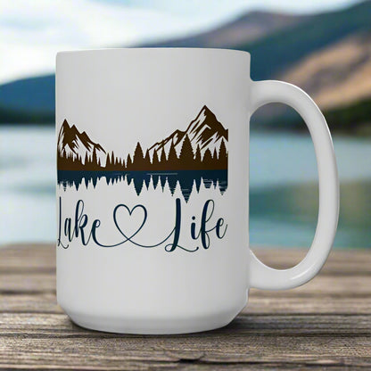 White 15 oz. ceramic mug with mountain and lake reflection design, featuring the phrase “Lake Life” – perfect for nature lovers.