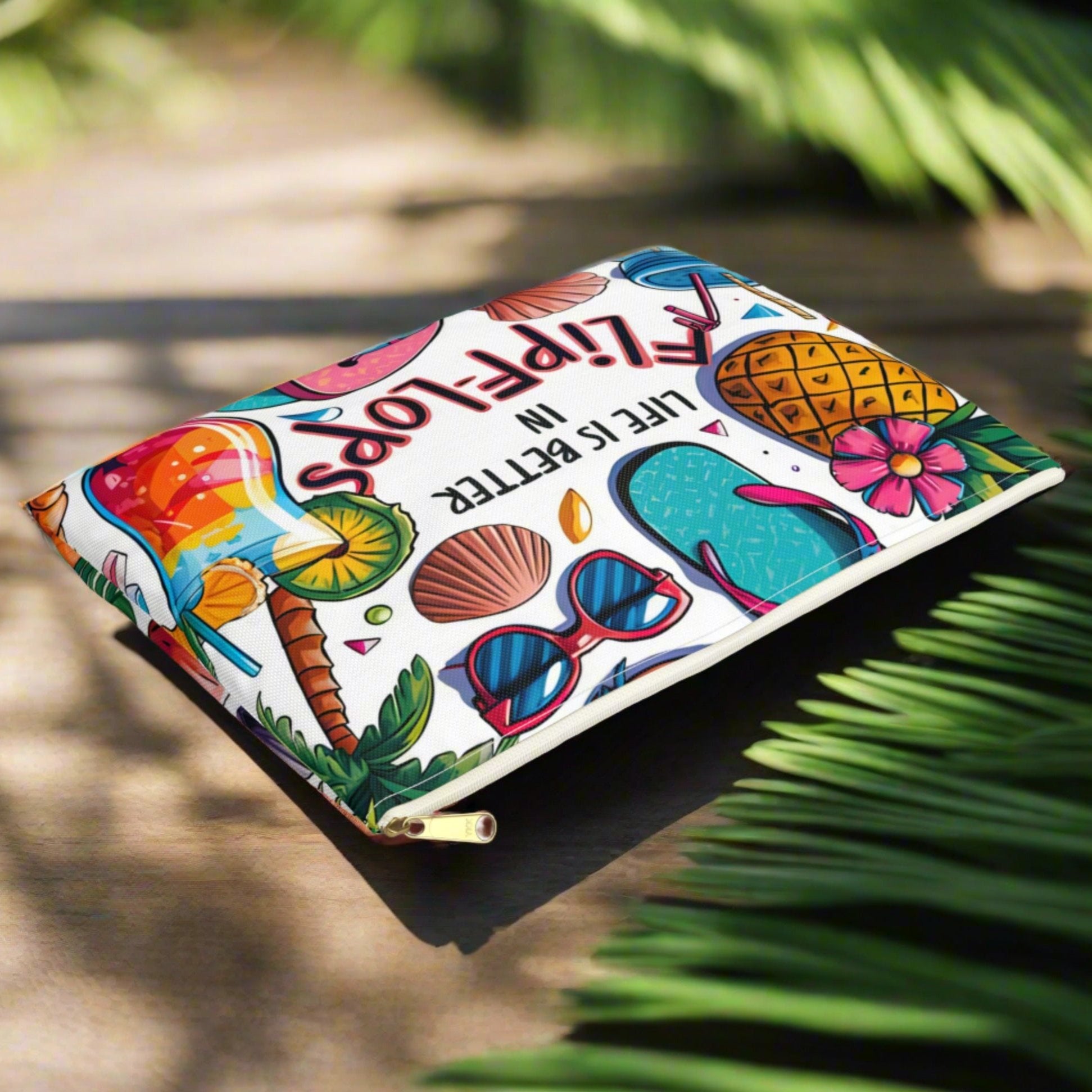 flat lay White accessories bag with black zipper with colorful beach graphics that says Life is Better in Flip Flops